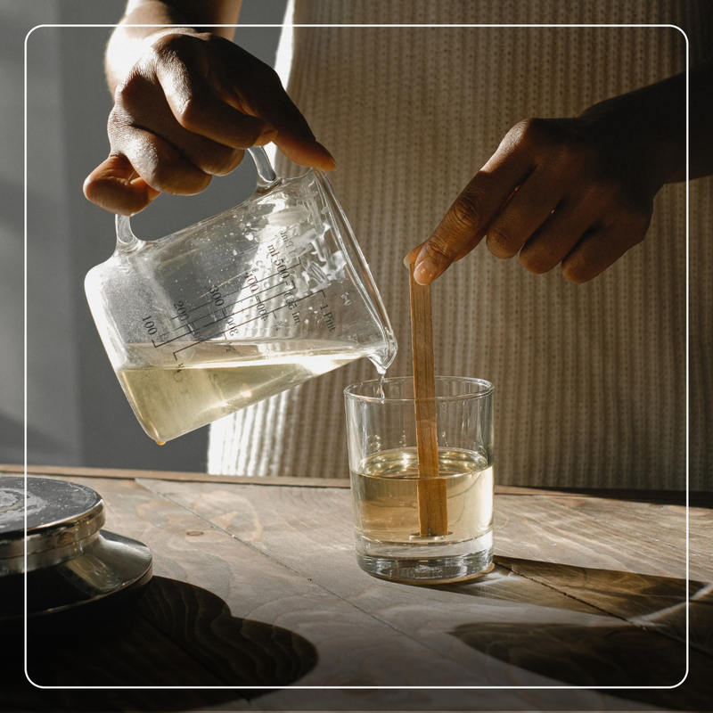 Pouring melted soy wax into a candle jar