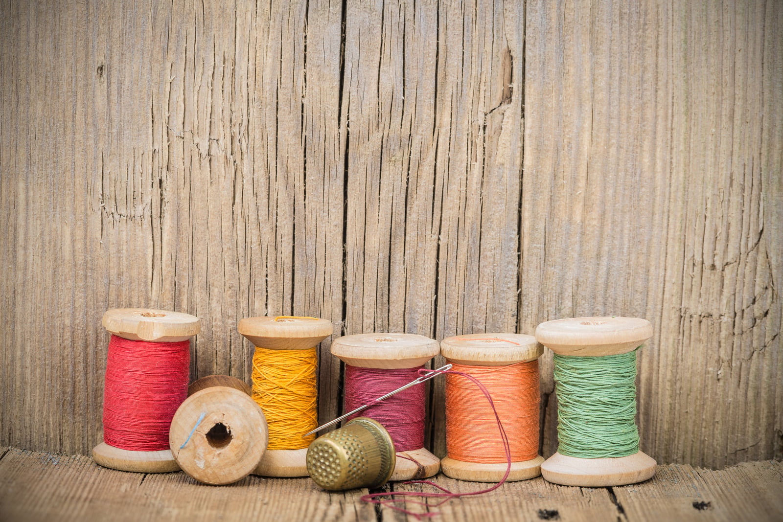 Cotton reels and a thimble on the sewing bench